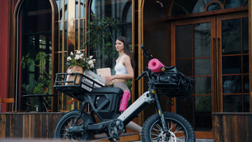 Pawkymo electric bike parked outside a café, loaded with groceries and flowers, showing modular cargo space for daily errands and shopping.
