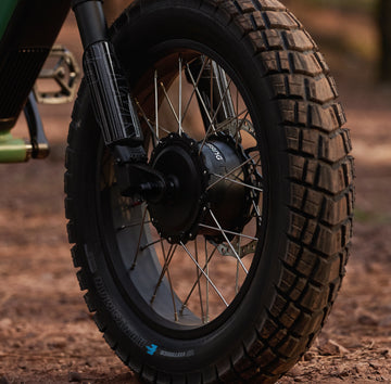 Close-up of the Pawkymo AR50 2X2 front wheel and suspension, highlighting smooth shock absorption for stable daily riding.